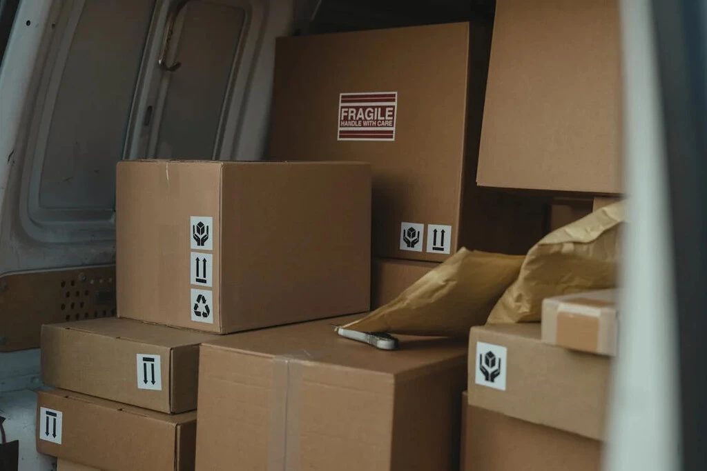 Cardboard boxes labeled fragile, stacked in the back of a van