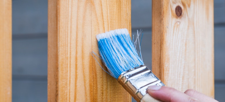 Person painting wooden posts.