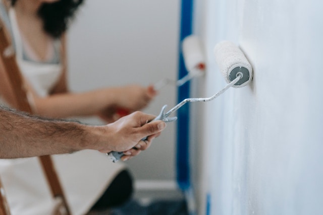 A man painting a white wall. Painting is one of the best ROI home improvements in 2022