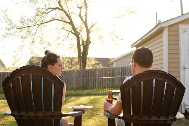 Two people sitting in a backyard.