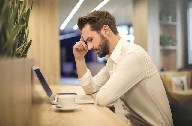 The man in front of his laptop is considering building a custom home.