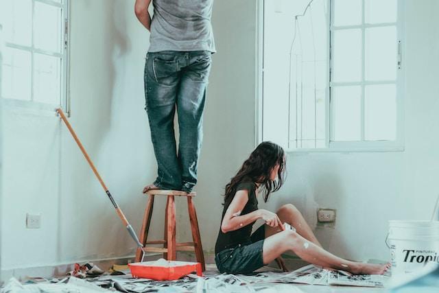 man and woman painting living room depicts home remodel