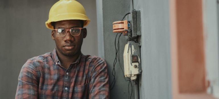 A contractor leaning against a wall