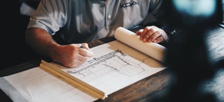 A person plotting the construction of a stilt home in coastal areas