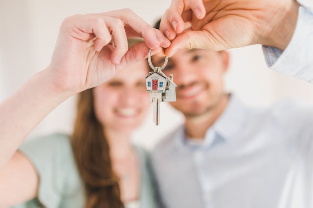 A happy, smiling couple holding a house key.