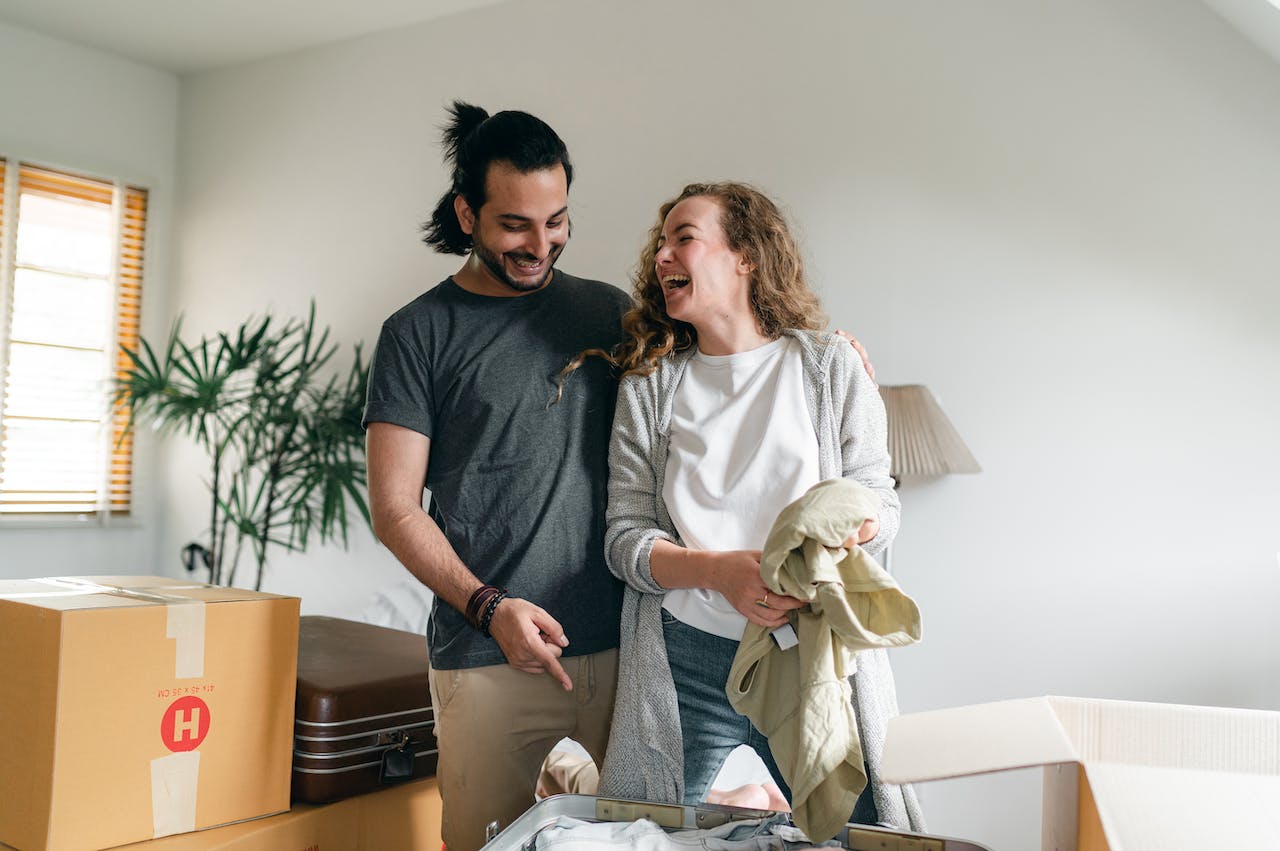 A couple unpacking boxes after reading the guide to moving into your newly built home