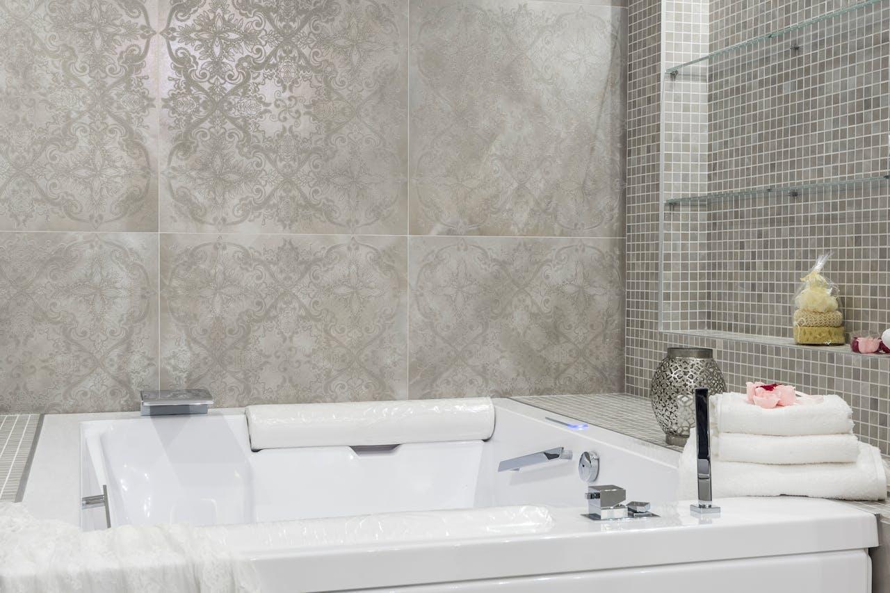 Modern interior of a bathroom with a bathtub and white towels on top of the bathtub.