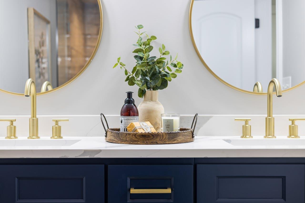 Bathroom essentials on the counter and two rounded mirrors on both sides.