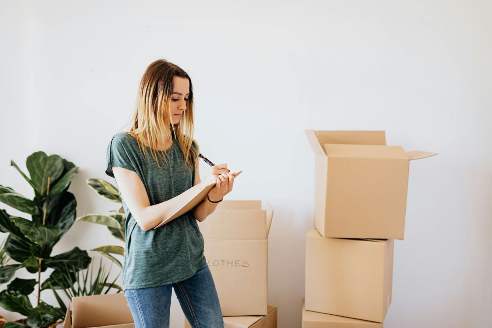 A woman making notes next to boxes while ensuring a secure environment