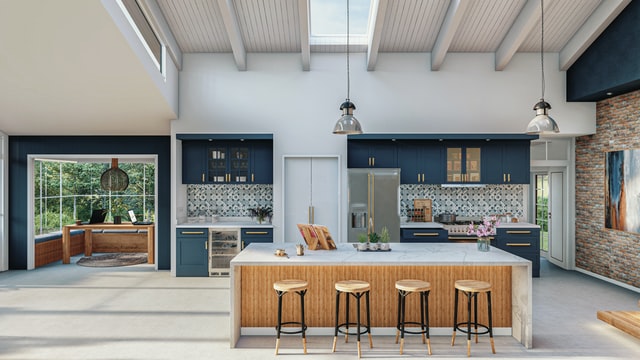 A large kitchen with blue cabinets, a large white and brown kitchen island with chairs, and a dedicated home office space with a desk and chair