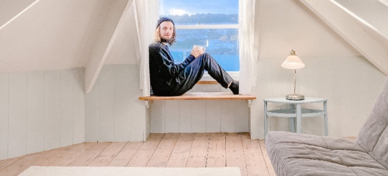 A man sitting in an attic where the remodeling was done in a minimalist style