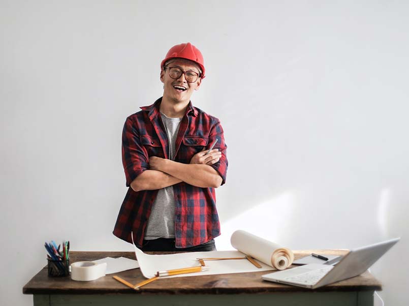 A smiling home builder in a checkered shirt.