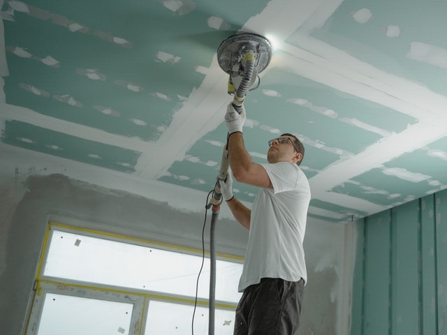 Man polishing any uneven areas of the ceiling.