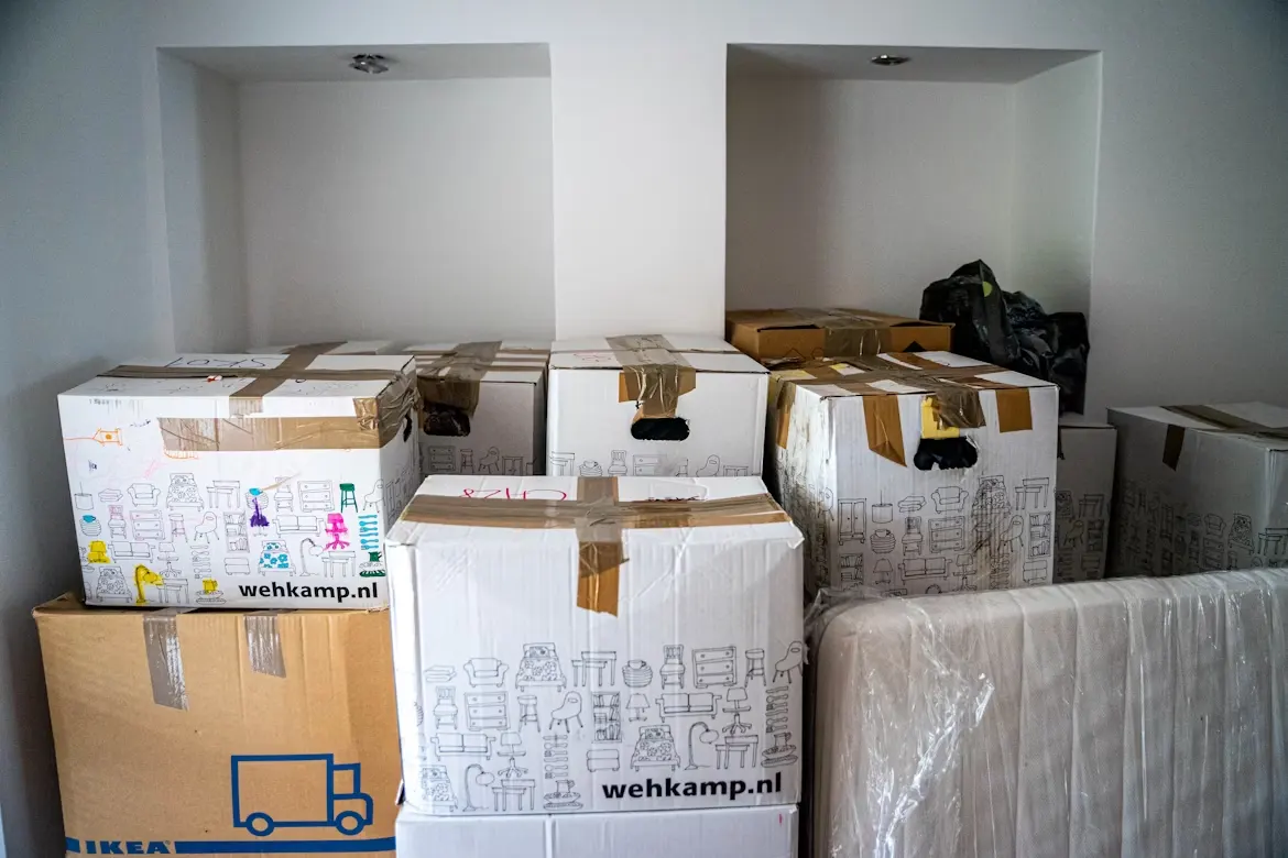 Brown cardboard boxes at the corner of a house