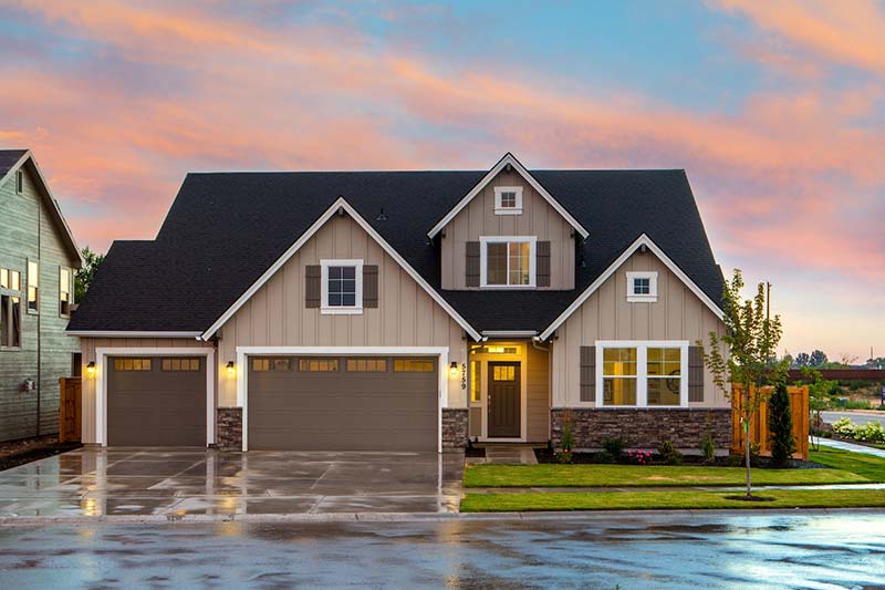 brown and gray painted house in front of a road