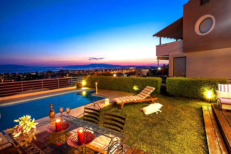 A beautiful house with a pool, a table, and chairs