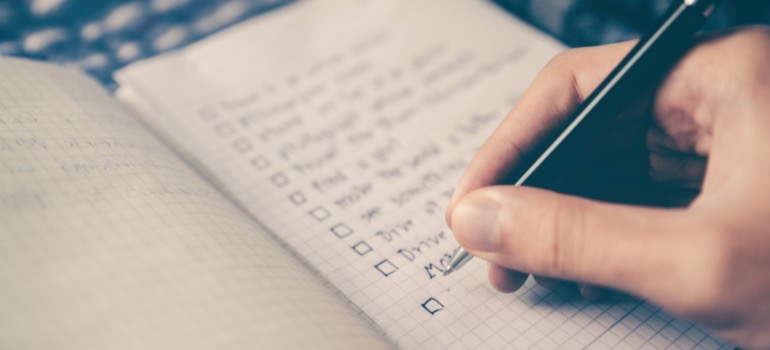 A picture of a person writing down a plan for using recycled materials in your home remodel